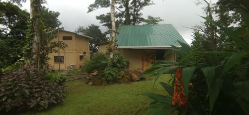 a house with a green roof in a yard at Greenhouse Lofts Miravalles in Aguas Claras