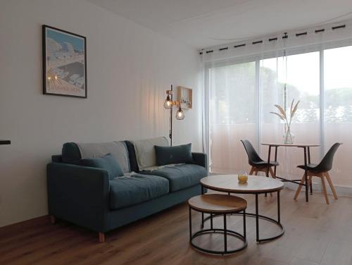 un salon avec un canapé bleu et une table dans l'établissement L'escale bleue Méditerranée, à La Grande Motte