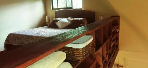 a bedroom with a bed with a wooden rail at Greenhouse Lofts Miravalles in Aguas Claras