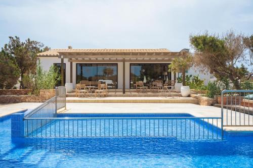 a swimming pool in front of a house at Apartamentos Punta Rasa in Cala Saona