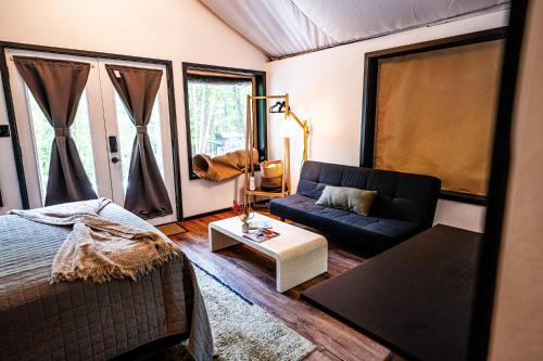 a bedroom with a bed and a couch and a table at Starlight Haven at Weiss Lake in Gaylesville