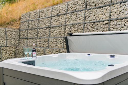 a bath tub with a glass of wine and a wine bottle at Hockley House by Bloom Stays in Folkestone