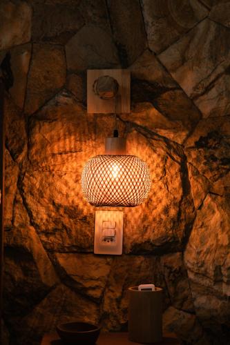 a light hanging from a stone wall with a socket at Saona Bangalôs Taíba in Taíba