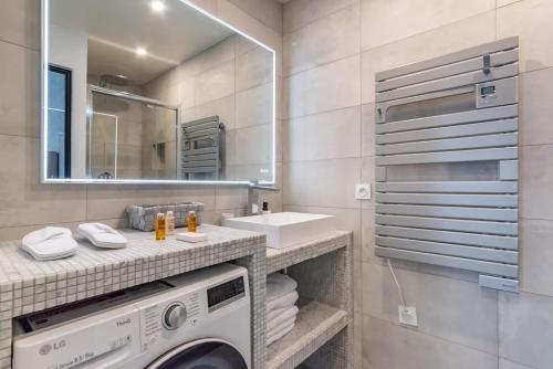 une salle de bain avec une machine à laver et un lavabo dans l'établissement Renovated apartment close to Opera, à Paris