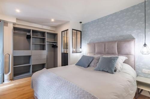 une chambre avec un grand lit blanc et un bureau dans l'établissement Renovated apartment close to Opera, à Paris