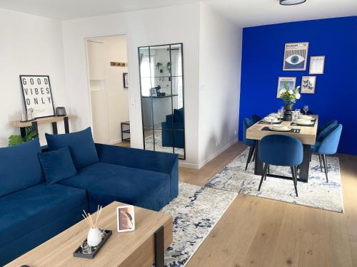 un salon avec un canapé bleu et une table dans l'établissement Majestic Blue- Parking Privé, à Ivry-sur-Seine