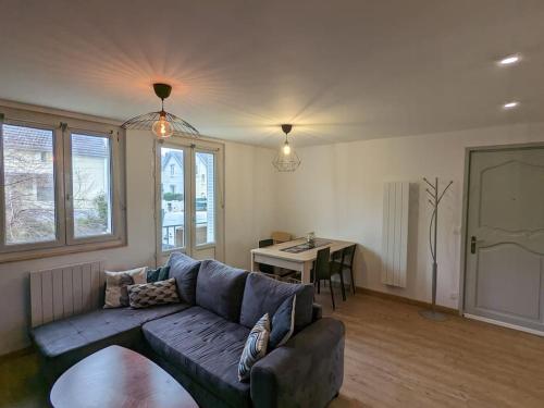 un salon avec un canapé et une table dans l'établissement Appartement proche Parc Expo Nancy, à Jarville-la-Malgrange