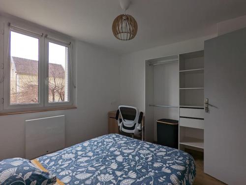 une chambre avec un lit, une chaise et une fenêtre dans l'établissement Appartement proche Parc Expo Nancy, à Jarville-la-Malgrange