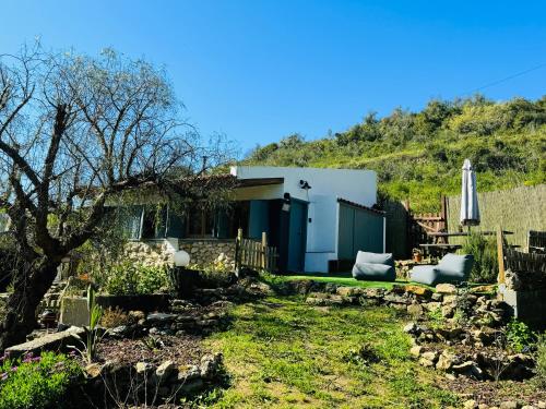 a small house in a yard with a hill in the background at Casas Rio Verde in Cheleiros