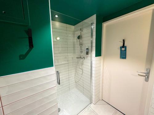 巴黎All Suites Appart Hôtel et Hôtel - Paris 13 - Porte d'Italie的浴室里有玻璃门的淋浴间