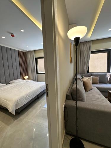 a bedroom with two beds and a couch at Chic Apartments For Rent ave0-9 in Amman