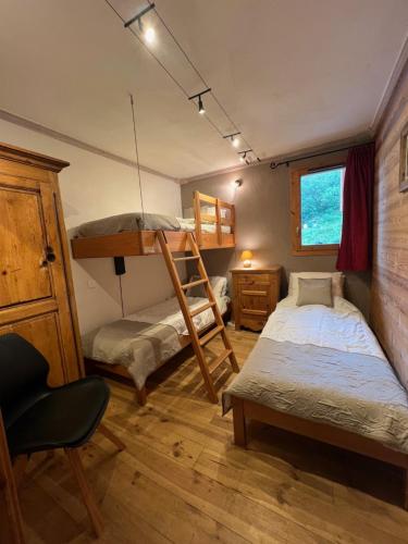- une chambre avec 2 lits superposés et une chaise dans l'établissement Chalet le Chamois-Arolles- Arcs 2000-Alpes-France, à Bourg-Saint-Maurice