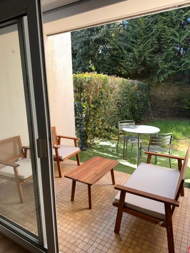 d'une terrasse avec des bancs, une table et des chaises. dans l'établissement Superbe appartement vannetais, à Vannes
