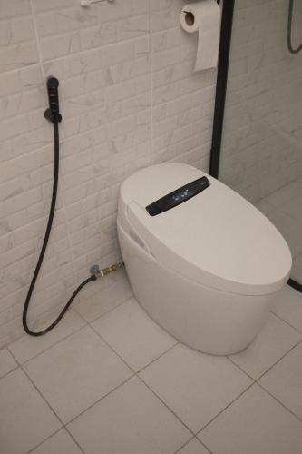 a white toilet in a bathroom with a hose at Sunset beach villa 7 O3 villas in Haad Pleayleam