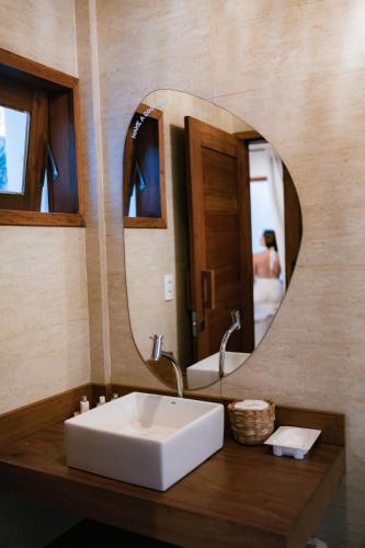 a bathroom with a white sink and a mirror at Saona Bangalôs Taíba in Taíba