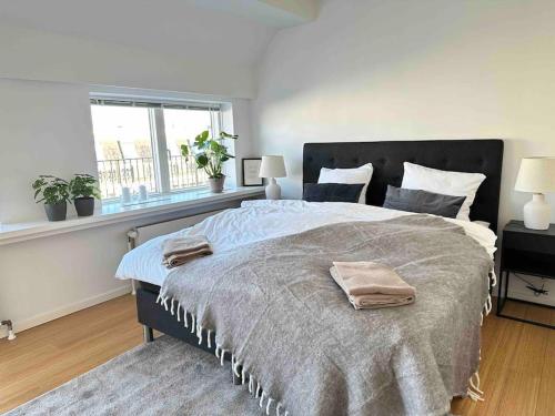 a bedroom with a large bed and a window at Penthouse-Nordic-Citycenter-Balcony in Copenhagen