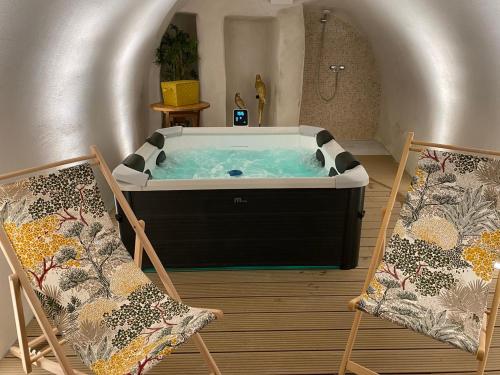 - une baignoire dans une chambre avec 2 chaises dans l'établissement Le Buisson Caché, à Buisson