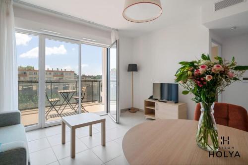 - un salon avec une table et un vase de fleurs dans l'établissement Le Plein Sud - À Avignon - 376B, à Avignon