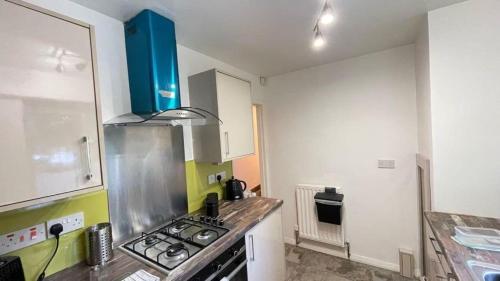 a kitchen with a stove top oven in a room at Spacious 3-bed apartment close to Birmingham City with free parking with Netflix contractor stays welcome in Birmingham
