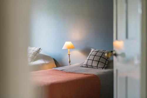 a bedroom with a bed with a lamp and a pillow at Craythornes by Bloom Stays in New Romney