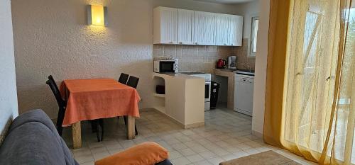 a kitchen with a table and a small kitchen with a table and chairs at Résidence les Hameaux de Bocca del Oro in Porto-Vecchio