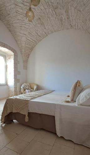 a bedroom with a large bed in a white room at Mazzini 5 in Locorotondo