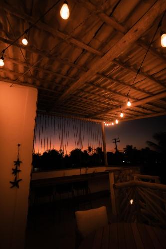 a room with a balcony with a view of the sunset at Saona Bangalôs Taíba in Taíba