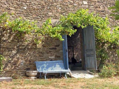 a blue bench sitting in front of a brick building at Glamping tent in de rust, met zwembad, badkamer en keuken in Lacapelle-Pinet
