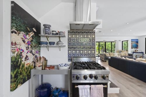 a kitchen with a stove and a living room at The Waterhouse- Amazing Villa With Infinity Pool in Miami
