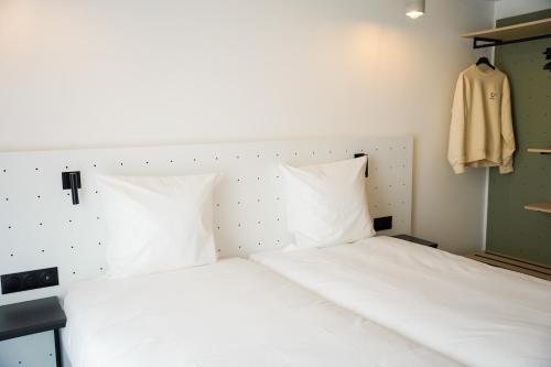 a bedroom with a white bed with a headboard at All Suites Appart Hôtel et Hôtel - Paris 13 - Porte d'Italie in Paris