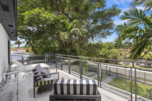 a balcony with two chairs and a railing at The Waterhouse- Amazing Villa With Infinity Pool in Miami
