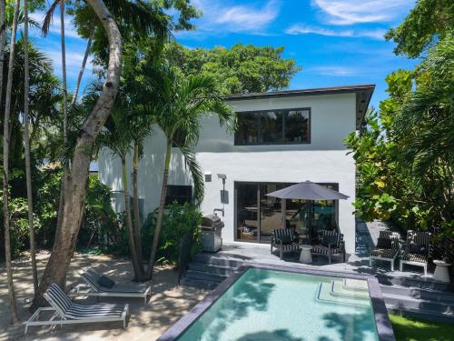 a house with a swimming pool and palm trees at The Waterhouse- Amazing Villa With Infinity Pool in Miami
