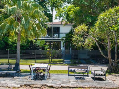 a group of benches and tables in front of a building at The Waterhouse- Amazing Villa With Infinity Pool in Miami