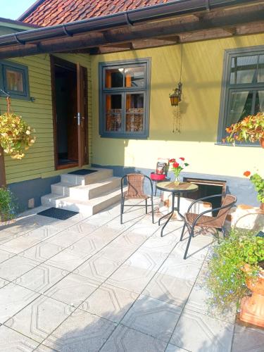 a patio with chairs and a table in front of a house at STĀRĶA APARTAMENTI in Kuldīga