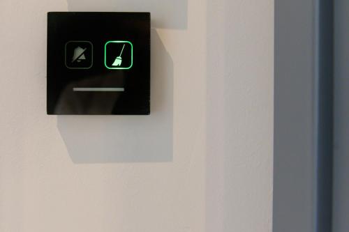 フォッローニカにあるRiva Roomsの壁に緑の矢印が付いた黒いスイッチ