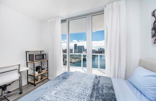 Un dormitorio con una cama y una ventana grande. en 2 Bed 2 Bath With Amazing Bay View And Luxury Pool, en Hallandale Beach