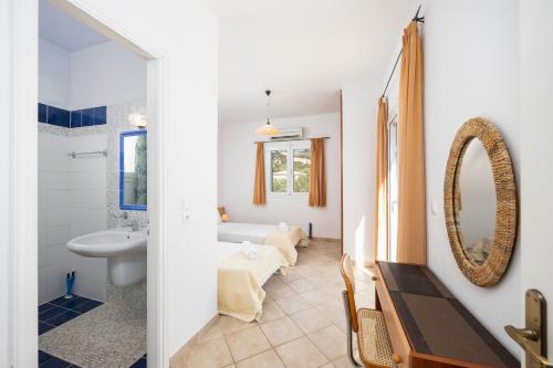a bathroom with a tub and a sink and a mirror at Villa Thalia Katerina in Mousata