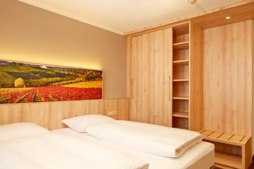a bedroom with two beds and a painting on the wall at H+ Hotel Stuttgart Herrenberg in Herrenberg