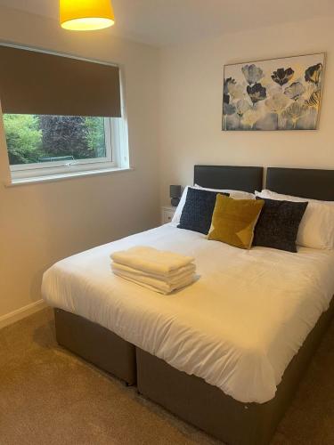 a bedroom with a bed with towels on it at Homely 3-bed home Milton Keynes in Simpson