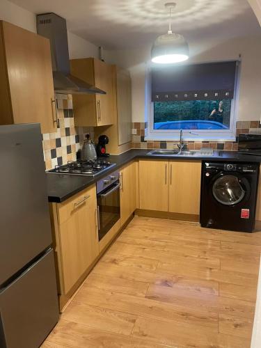 a kitchen with a sink and a dishwasher at Homely 3-bed home Milton Keynes in Simpson