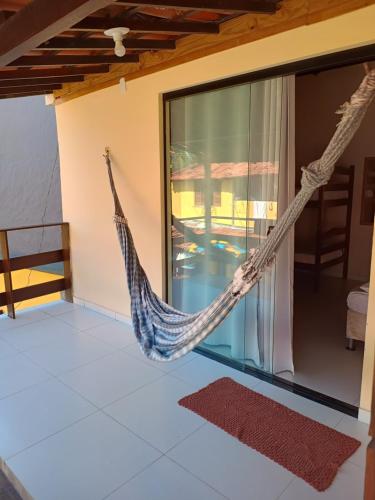 a hammock hanging on the side of a house at Dendê Jazz Hostel e Pousada in Morro de São Paulo