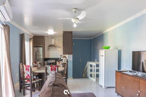 eine Küche mit einem Kühlschrank und einem Tisch mit Stühlen in der Unterkunft 150m do mar! Cobertura Duplex com Piscina Privada in Bombinhas