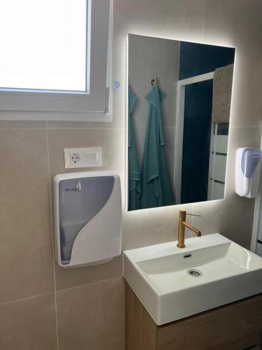 a bathroom with a sink and a mirror at Apartamento Playa El Palmar 2 in El Palmar