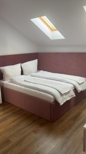 a large bed in a bedroom with a skylight at Apartament Giroc in Fratelia