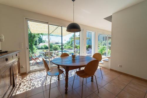 a kitchen and dining room with a table and chairs at La Maison Château d'Eau : piscine pour 6/8 pers in Saint-Benoît