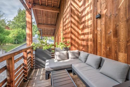 une terrasse couverte avec un canapé sur une terrasse en bois dans l'établissement Appartement Crystal - 4 étoiles - Welkeys, à Megève