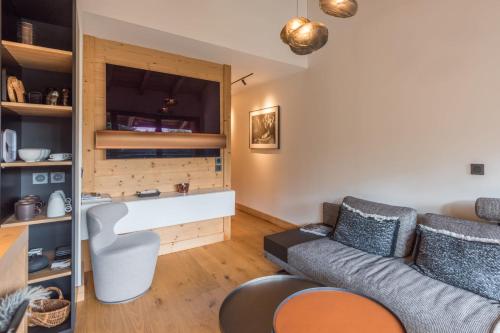 un salon avec un canapé et une chaise dans l'établissement Appartement Crystal - 4 étoiles - Welkeys, à Megève