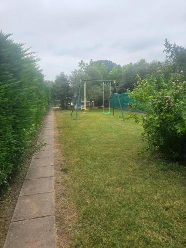a park with a swing set in the grass at Appartement familial avec jardin et vue sur lac à Clairac, 80 m² in Clairac