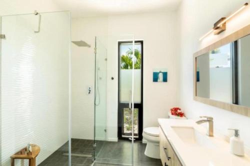 a bathroom with a shower and a toilet and a sink at Grace Bay Vacation Villa in Long Bay Hills