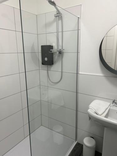 a shower with a glass door in a bathroom at The Rhu Inn in Rhu